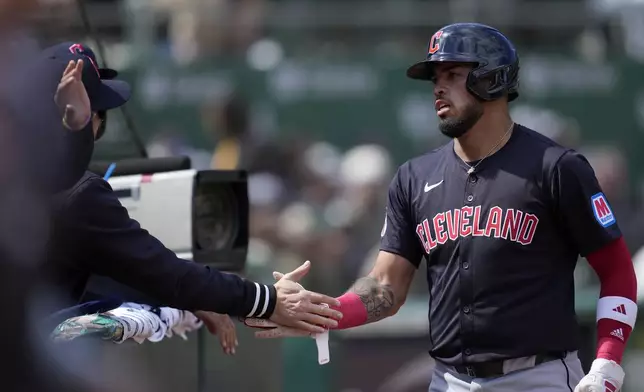 Cleveland Guardians' Gabriel Arias is congratulated by teammates after scoring against the Oakland Athletics during the fourth inning of a baseball game in Oakland, Calif., Saturday, March 30, 2024. (AP Photo/Jeff Chiu)