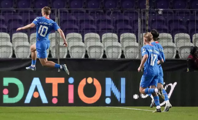 Iceland's Albert Gudmundsson, left, celebrates with his teammates after scoring his side's first goal during the Euro 2024 qualifying play-off soccer match between Israel and Iceland, at Szusza Ferenc Stadium in Budapest, Hungary, Thursday, March 21, 2024. (AP Photo/Darko Vojinovic)