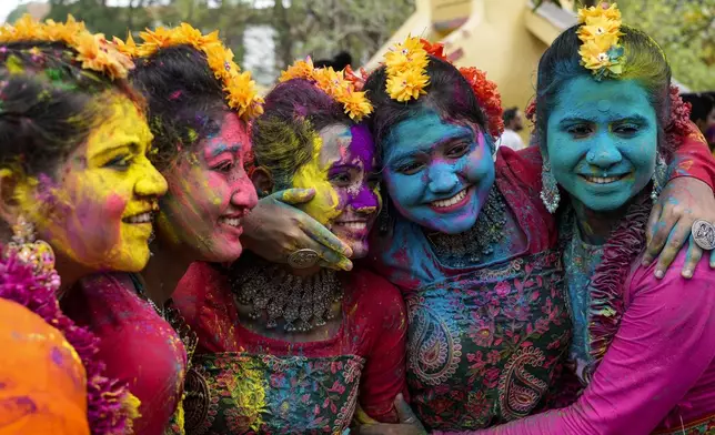 Women, with their faces smeared with coloured powder, pose for a photograph as they celebrate Holi, the festival of colors, in Kolkata, India, Monday, March 25, 2024. (AP Photo/Bikas Das)