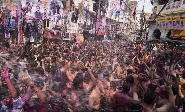 Revelers, faces smeared with colored powder, dance during celebrations to mark Holi, the Hindu festival of colors in Prayagraj, northern Uttar Pradesh state, India, Monday March 25, 2024. (AP Photo/Rajesh Kumar Singh)