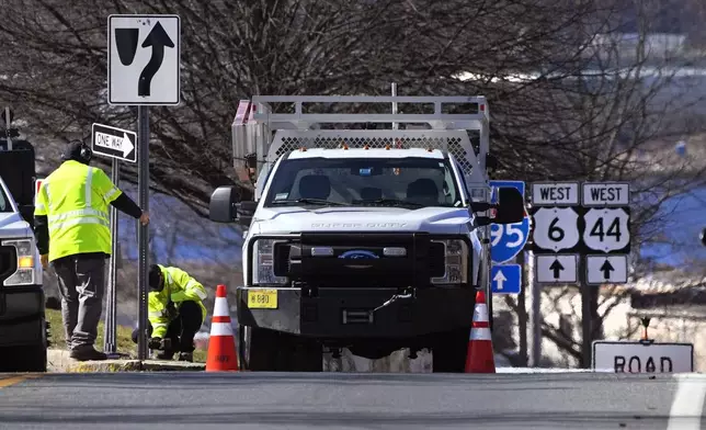 Rhode Island Department of Transportation workers replace a sign leading to the onramp to the Washington Bridge, Friday, March 8, 2024, in East Providence, R.I. The closure of a section of the bridge, and onramps, due to failure of some bridge components, has caused a significant loss to local businesses. (AP Photo/Charles Krupa)