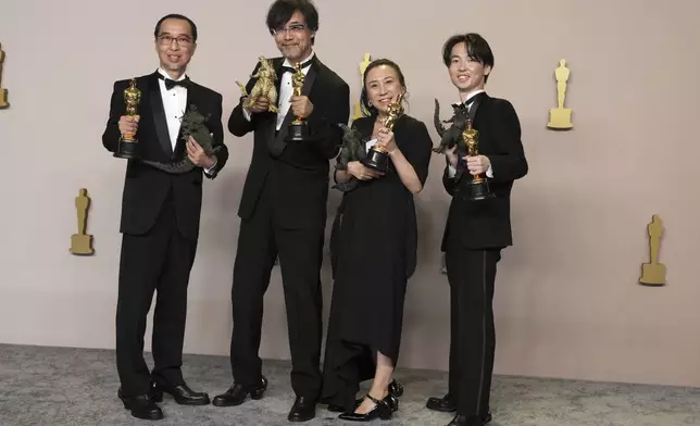 FILE - Masaki Takahashi, from left, Takashi Yamazaki, Kiyoko Shibuya, and Tatsuji Nojima pose in the press room with the award for best visual effects for "Godzilla Minus One" at the Oscars on March 10, 2024, at the Dolby Theatre in Los Angeles. One Japanese creation grabbing attention on the Oscars red carpet wasn't a movie: the kitsch shoes that seemed to be clenched in Godzilla's claw. They were the work of Ryosuke Matsui, who recently described his joy at seeing “Godzilla Minus One” director Takashi Yamazaki and his Shirogumi special-effects team walk the red carpet and win the visual effects Oscar, all while wearing his shoes. (Photo by Jordan Strauss/Invision/AP, File)