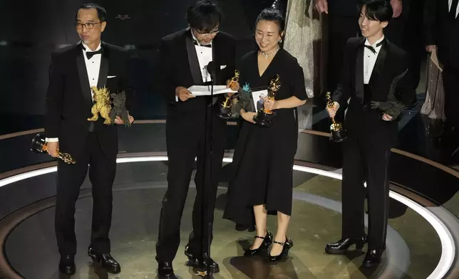 FILE - Masaki Takahashi, from left, Takashi Yamazaki, Kiyoko Shibuya, and Tatsuji Nojima accept the award for best visual effects for "Godzilla Minus One" during the Oscars on March 10, 2024, at the Dolby Theatre in Los Angeles. One Japanese creation grabbing attention on the Oscars red carpet wasn't a movie: the kitsch shoes that seemed to be clenched in Godzilla's claw. They were the work of Ryosuke Matsui, who recently described his joy at seeing “Godzilla Minus One” director Takashi Yamazaki and his Shirogumi special-effects team walk the red carpet and win the visual effects Oscar, all while wearing his shoes. (AP Photo/Chris Pizzello, File)