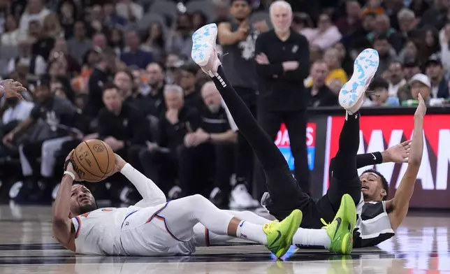 New York Knicks guard Jalen Brunson, left, look to pass the ball after he collided with San Antonio Spurs center Victor Wembanyama, right, during the second half of an NBA basketball game in San Antonio, Friday, March 29, 2024. (AP Photo/Eric Gay)