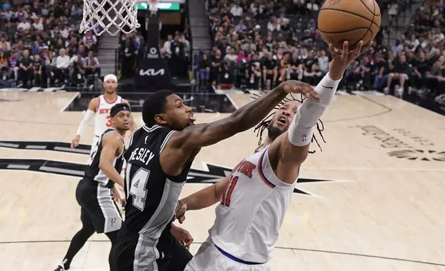 New York Knicks guard Jalen Brunson (11) drives to the basket against San Antonio Spurs guard Blake Wesley (14) during the second half of an NBA basketball game in San Antonio, Friday, March 29, 2024. (AP Photo/Eric Gay)