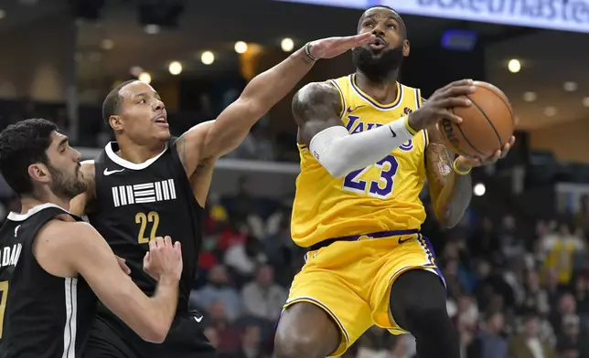 Los Angeles Lakers forward LeBron James (23) shoots against Memphis Grizzlies guard Desmond Bane (22) and forward Santi Aldama (7) in the first half of an NBA basketball game Wednesday, March 27, 2024, in Memphis, Tenn. (AP Photo/Brandon Dill)