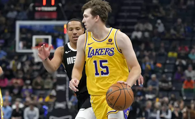Los Angeles Lakers guard Austin Reaves (15) dribbles the ball as Memphis Grizzlies guard Desmond Bane defends during the first half of an NBA basketball game Wednesday, March 27, 2024, in Memphis, Tenn. (AP Photo/Brandon Dill)