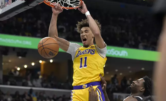 Los Angeles Lakers center Jaxson Hayes dunks against Memphis Grizzlies forward Jaren Jackson Jr., right, during the first half of an NBA basketball game Wednesday, March 27, 2024, in Memphis, Tenn. (AP Photo/Brandon Dill)