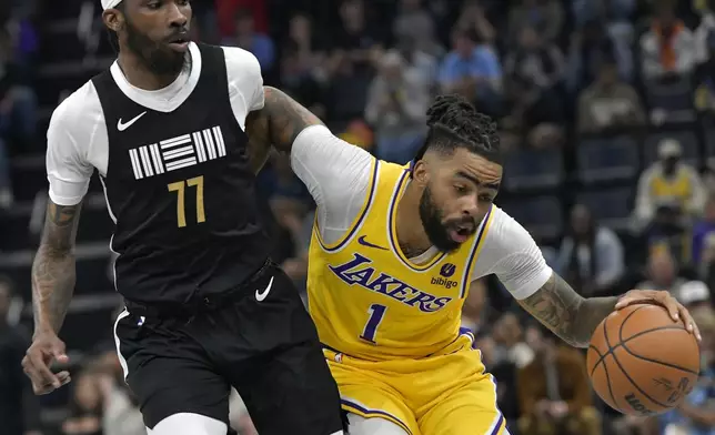 Los Angeles Lakers guard D'Angelo Russell (1) is defended by Memphis Grizzlies guard DeJon Jarreau (77) during the first half of an NBA basketball game Wednesday, March 27, 2024, in Memphis, Tenn. (AP Photo/Brandon Dill)