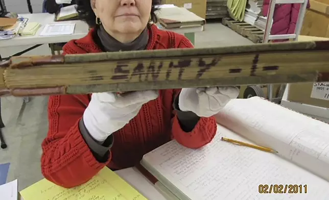 This Feb. 2, 2011, photo shows Niejse Steinkruger at the Alaska state archives in Juneau, Alaska, displaying a book of old court records that included sanity hearings. Steinkruger and other volunteers have spent years digging through old records to identify about 5,500 Alaskans who were committed to a mental hospital in Oregon before Alaska gained statehood. (Roger Brunner via AP)