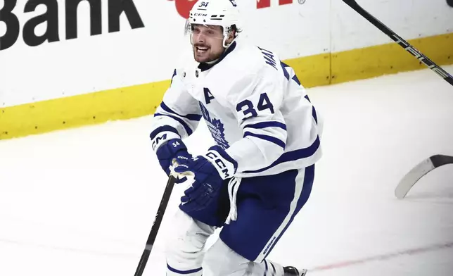 Toronto Maple Leafs center Auston Matthews (34) celebrates his 60th goal of the season during the third period of an NHL hockey game against the Buffalo Sabres, Saturday, March 30, 2024, in Buffalo, N.Y. (AP Photo/Jeffrey T. Barnes)