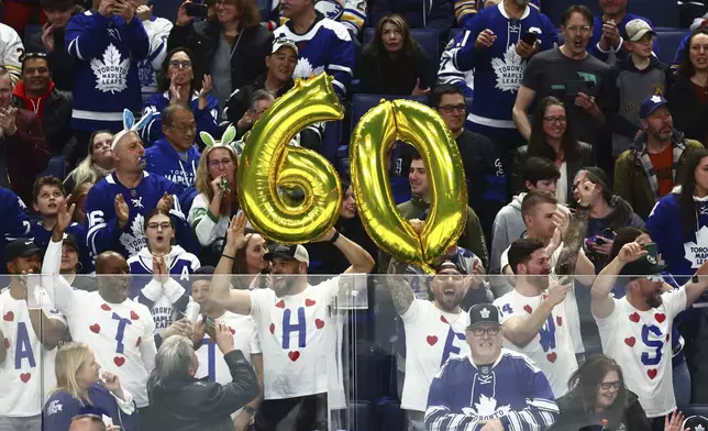 Toronto Maple Leafs fans celebrate Auston Matthews' 60th goal during the third period of an NHL hockey game against the Buffalo Sabres, Saturday, March 30, 2024, in Buffalo, N.Y. (AP Photo/Jeffrey T. Barnes)