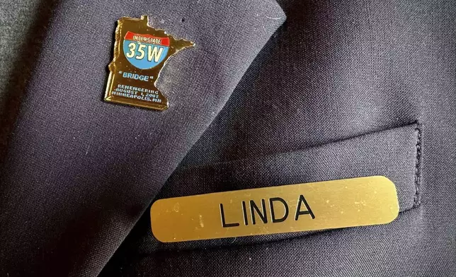 A gold pin in the shape of Minnesota – with the words "Interstate 35W 'Bridge' Remembering August 1, 2007" – is photographed on Linda Paul in St. Paul, Minn., on March 27, 2024. She survived the Interstate 35W bridge collapse in Minneapolis on Aug. 1, 2007, and was reminded of it after the Francis Scott Key Bridge in Baltimore collapsed on March 26, 2024. (AP Photo/Mark Vancleave)