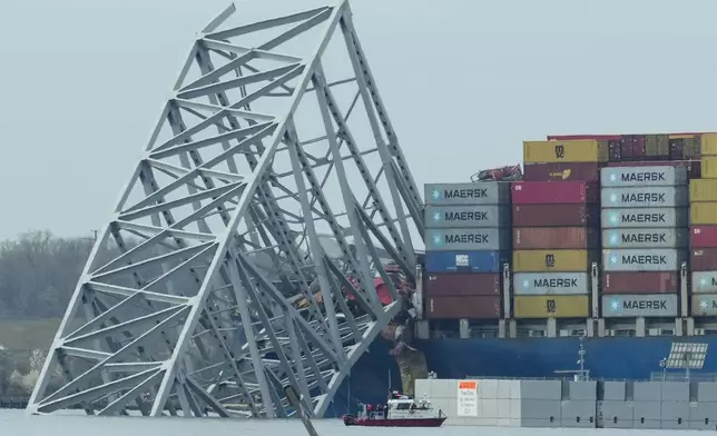 A container ship as it rests against wreckage of the Francis Scott Key Bridge on Tuesday, March 26, 2024, as seen from Dundalk, Md. The ship rammed into the major bridge in Baltimore early Tuesday, causing it to collapse in a matter of seconds and creating a terrifying scene as several vehicles plunged into the chilly river below. (AP Photo/Matt Rourke)