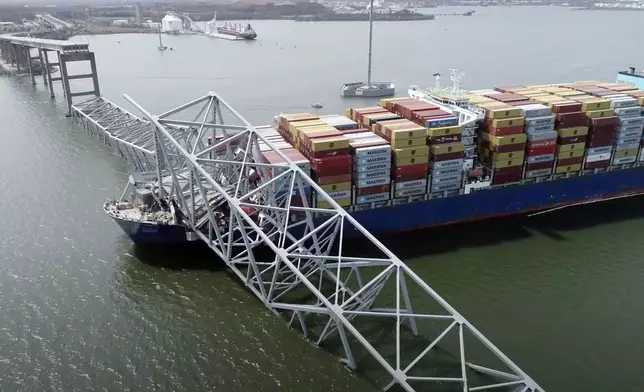 In this image taken from video released by the National Transportation and Safety Board, the cargo ship Dali is stuck under part of the structure of the Francis Scott Key Bridge after the ship hit the bridge, Tuesday, March 26, 2024, in Baltimore. (NTSB via AP)