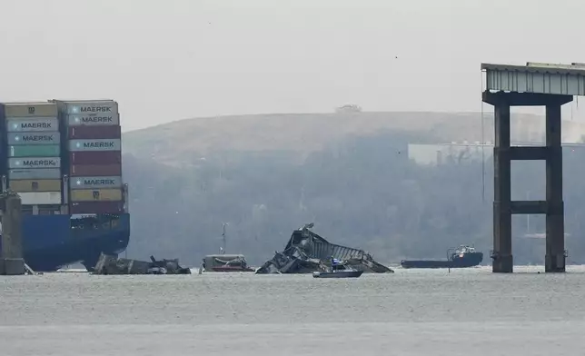 A container ship rests against wreckage of the Francis Scott Key Bridge on Wednesday, March 27, 2024, in Baltimore, Md. Recovery efforts resumed Wednesday for the construction workers who are presumed dead after the cargo ship hit a pillar of the bridge, causing the structure to collapse. (AP Photo/Matt Rourke)