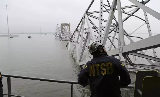 In this image released by the National Transportation and Safety Board, a NTSB investigator is seen on the cargo vessel Dali, which struck and collapsed the Francis Scott Key Bridge, Wednesday, March 27, 2024 in Baltimore. (Peter Knudson/NTSB via AP)