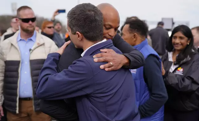 Maryland Gov. Wes Moore and Transportation Secretary Pete Buttigieg embrace after a news conference near the scene where a container ship collided with a support on the Francis Scott Key Bridge, in Dundalk, Md., Tuesday, March 26, 2024. (AP Photo/Matt Rourke)
