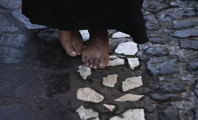 A bare-footed penitent walks in a Holy Week procession, in Taxco, Mexico, Thursday, March 28, 2024. (AP Photo/Fernando Llano)