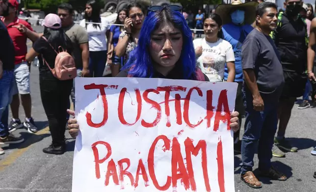 A woman holds a sign with a message that reads in Spanish: "Justice for Cami" in reference to an 8-year-old girl who disappeared the previous day, in Taxco, Mexico, Thursday, March 28, 2024. The 8-year-old girl disappeared Wednesday; her body was found on a road on the outskirts of the city early Thursday. (AP Photo/Fernando Llano)