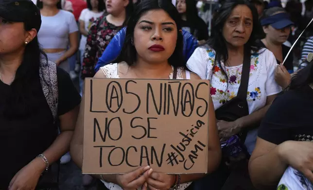 A woman holds a sign with a message that loosely translates from Spanish: "Children should not be harmed", during a demonstration protesting the kidnapping and killing of an 8-year-old girl, in the main square of Taxco, Mexico, Thursday, March 28, 2024. Hours earlier a mob beat a woman to death because she was suspected of kidnapping and killing the young girl. (AP Photo/Fernando Llano)