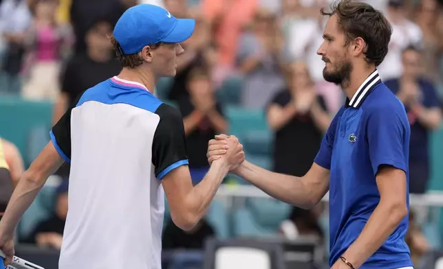 Jannik Sinner, of Italy, left, shakes hands with Daniil Medvedev, of Russia, right, after winning their semifinal match at the Miami Open tennis tournament, Friday, March 29, 2024, in Miami Gardens, Fla. (AP Photo/Lynne Sladky)