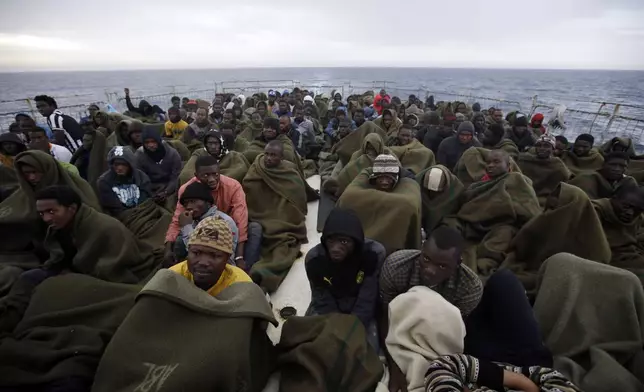 FILE - Migrants sit on the deck of the Belgian Navy vessel Godetia after they were saved at sea during a search and rescue mission in the Mediterranean Sea off the Libyan coasts, Wednesday, June 24, 2015. The UN migration agency marks a decade since the launch of the Missing Migrants Project, documenting more than 63,000 deaths around the world. More than two-thirds of victims remain unidentified highlighting the size of the crisis and the suffering of families who rarely receive definitive answers. (AP Photo/Gregorio Borgia, File)