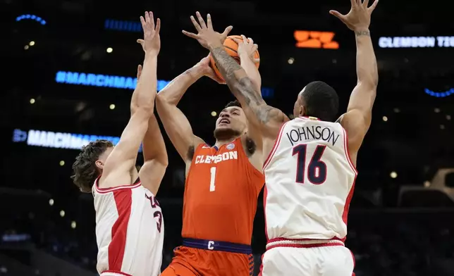 Clemson guard Chase Hunter (1) drives to the basket between Arizona guard Pelle Larsson (3) and forward Keshad Johnson (16) during the first half of a Sweet 16 college basketball game in the NCAA tournament Thursday, March 28, 2024, in Los Angeles. (AP Photo/Ashley Landis)