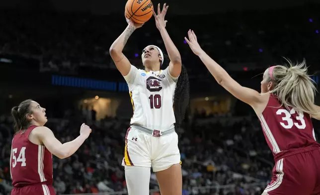 South Carolina center Kamilla Cardoso (10) puts up a shot against Indiana guard Sydney Parrish (33) and forward Mackenzie Holmes (54) during the first quarter of a Sweet Sixteen round college basketball game during the NCAA Tournament, Friday, March 29, 2024, in Albany, N.Y. (AP Photo/Mary Altaffer)