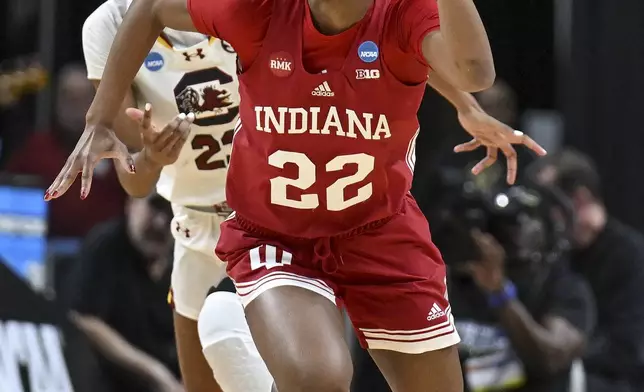 Indiana guard Chloe Moore-McNeil (22) pushes the ball down court on a fast break against South Carolina guard Bree Hall (23) during the first quarter of a Sweet Sixteen round college basketball game during the NCAA Tournament, Friday, March 29, 2024, in Albany, N.Y. (AP Photo/Hans Pennink)