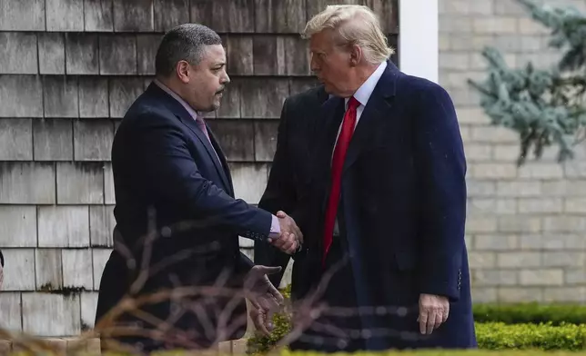 New York City Police Commissioner Edward A. Caban, left, shakes hands with Former President Donald Trump as he arrives for the wake of New York City police officer Jonathan Diller, Thursday, March 28, 2024, in Massapequa Park, N.Y. Diller was shot and killed Monday during a traffic stop, the city's mayor said. It marked the first slaying of an NYPD officer in two years. (AP Photo/Frank Franklin II)