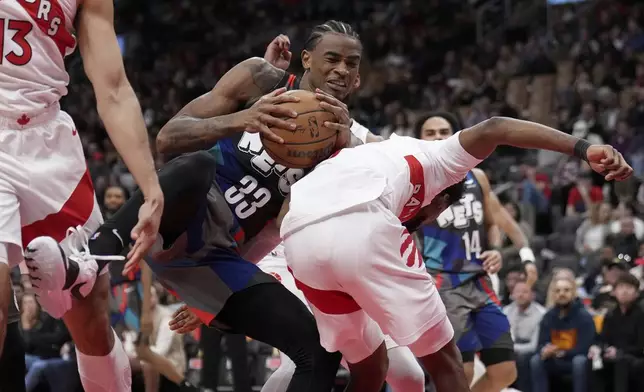 Brooklyn Nets center Nic Claxton (33) vies for the loose ball with Toronto Raptors' Kobi Simmons during the second half of an NBA basketball game in Toronto, Monday, March 25, 2024. (Nathan Denette/The Canadian Press via AP)