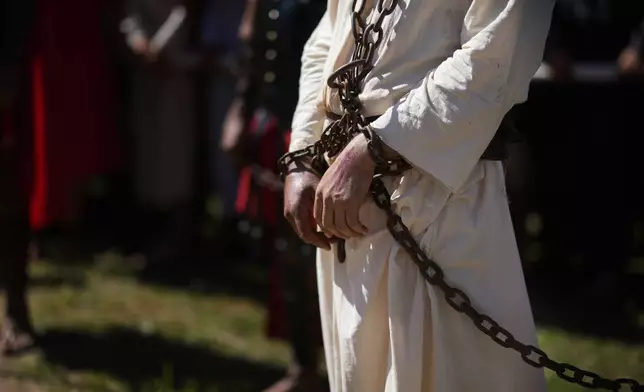 An actor, playing the role of Jesus Christ, stands in chains during a Way of the Cross reenactment, as part of Holy Week celebrations, in Atyra, Paraguay, Friday, March 29, 2024. Holy Week commemorates the last week of Jesus' earthly life which culminates with his crucifixion on Good Friday and his resurrection on Easter Sunday. (AP Photo/Jorge Saenz)