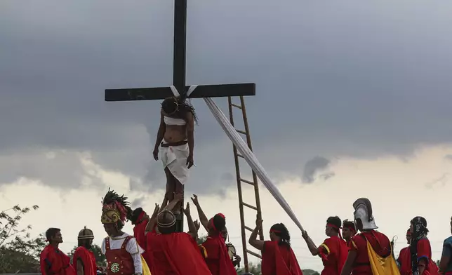 Ruben Enaje is lowered from the cross during the reenactment of Jesus Christ's sufferings as part of Good Friday rituals in San Pedro Cutud, north of Manila, Philippines, Friday, March 29, 2024. The Filipino villager was nailed to a wooden cross for the 35th time to reenact Jesus Christ’s suffering in a brutal Good Friday tradition he said he would devote to pray for peace in Ukraine, Gaza and the disputed South China Sea. (AP Photo/Gerard V. Carreon)