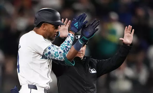 Seattle Mariners' Julio Rodríguez reacts to hitting a double against the Boston Red Sox during the first inning of an opening-day baseball game Thursday, March 28, 2024, in Seattle. (AP Photo/Lindsey Wasson)