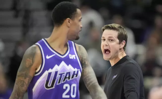 Utah Jazz coach Will Hardy speaks with John Collins (20) during the first half of the team's NBA basketball game against the Houston Rockets on Friday, March 29, 2024, in Salt Lake City. (AP Photo/Rick Bowmer)