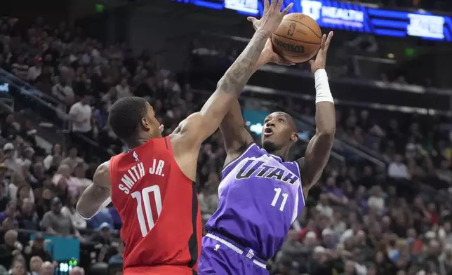 Utah Jazz guard Kris Dunn (11) shoots as Houston Rockets forward Jabari Smith Jr. (10) defends during the first half of an NBA basketball game Friday, March 29, 2024, in Salt Lake City. (AP Photo/Rick Bowmer)