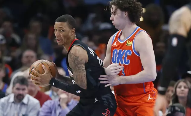 Houston Rockets forward Jabari Smith Jr., left, is defended by Oklahoma City Thunder guard Josh Giddey during the first half of an NBA basketball game Wednesday, March 27, 2024, in Oklahoma City. (AP Photo/Nate Billings)