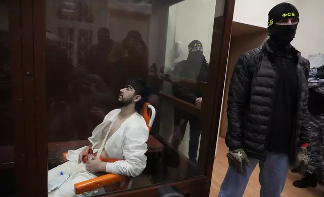 Mukhammadsobir Faizov, a suspect in Friday's shooting at the Crocus City Hall, sits in a glass cage in the Basmanny District Court in Moscow, Russia, Sunday, March 24, 2024. The four men charged with the massacre at a Moscow theater have been identified by the Russian government as citizens of Tajikistan, some of the thousands who migrate each year from the poorest of the former Soviet republics to scrape out marginal existences. (AP Photo/Alexander Zemlianichenko)