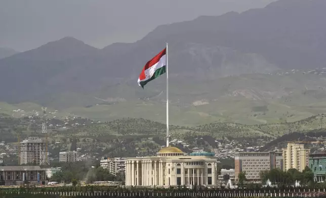 FILE - A national flag of Tajikistan is hoisted to the top of the 165-meter (541.34 feet) flagpole in Dushanbe, Tajikistan, Tuesday, May 24, 2011. The four men charged with the massacre at a Moscow theater have been identified by the Russian government as citizens of Tajikistan, some of the thousands who migrate each year from the poorest of the former Soviet republics to scrape out marginal existences. (AP Photo/Olga Tutubalina, File)