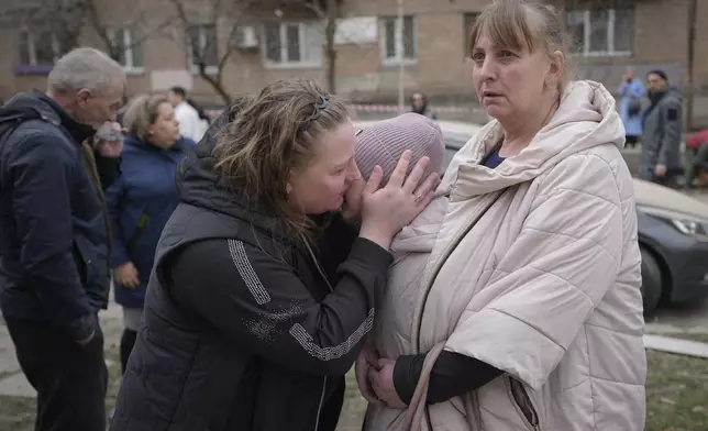 Residents on the Pechersk district react as they stand near an area damaged by a Russian air attack in Kyiv, Ukraine, Monday March 25, 2024. Five people were injured in the strike, two were hospitalised.(AP Photo/Vadim Ghirda)