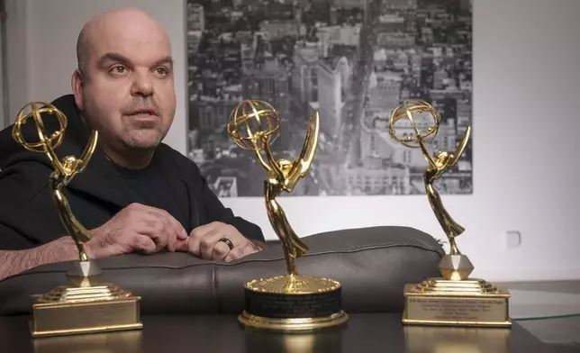 Emmy Award-winning producer Johnathan Walton poses for a photo with his Emmy Awards at his apartment in downtown Los Angeles, Monday, March 25, 2024. Walton was scammed by con artist Marianne "Mair" Smyth, who is now facing extradition to the United Kingdom. Walton started a podcast in 2021, “Queen of the Con,” to warn others about Smyth after he said he was fleeced out of nearly 0,000. (AP Photo/Damian Dovarganes)