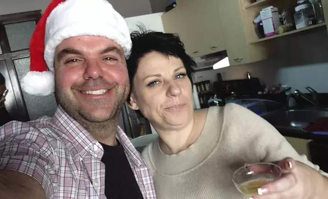 In this image provided by Johnathan Walton, Walton and Marianne "Mair" Smyth pose for a selfie in December 2013, at her tree trimming Christmas party in downtown Los Angeles. Smyth is in a Maine jail awaiting a hearing in April 2024 that will decide whether she can be extradited to the United Kingdom over a scam dating back more than 15 years in Northern Ireland. She is accused of stealing more than $170,000 from at least five victims from 2008 to 2010 in Northern Ireland, according to court records. (Johnathan Walton via AP)