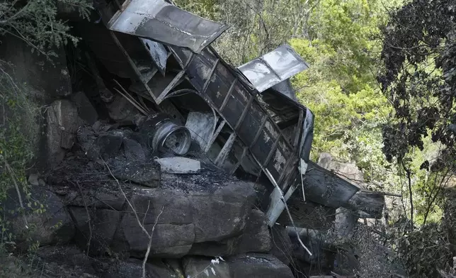 The wreckage off a bus lays in a ravine a day after it plunged off a bridge on the Mmamatlakala mountain pass between Mokopane and Marken, around 300km (190 miles) north of Johannesburg, South Africa, Friday, March 29, 2024. A bus carrying worshippers on a long-distance trip from Botswana to an Easter weekend church gathering in South Africa plunged off a bridge on a mountain pass Thursday and burst into flames as it hit the rocky ground below, killing at least 45 people, authorities said. The only survivor was an 8-year-old child who was receiving medical attention for serious injuries. (AP Photo/Themba Hadebe)