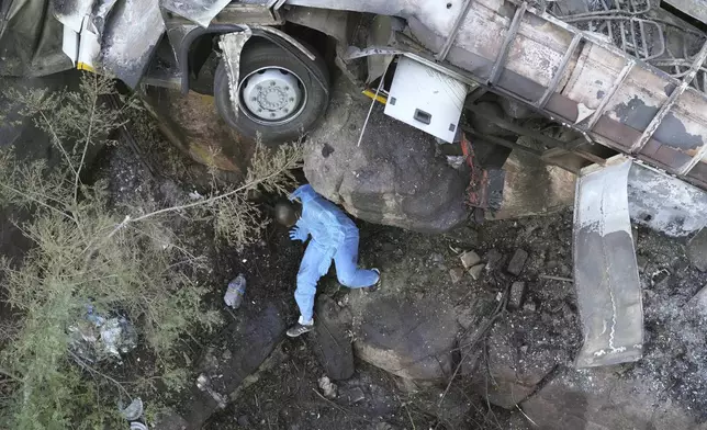 The wreckage off a bus lays in a ravine a day after it plunged off a bridge on the Mmamatlakala mountain pass between Mokopane and Marken, around 300km (190 miles) north of Johannesburg, South Africa, Friday, March 29, 2024. A bus carrying worshippers on a long-distance trip from Botswana to an Easter weekend church gathering in South Africa plunged off a bridge on a mountain pass Thursday and burst into flames as it hit the rocky ground below, killing at least 45 people, authorities said. The only survivor was an 8-year-old child who was receiving medical attention for serious injuries. (AP Photo/Themba Hadebe)