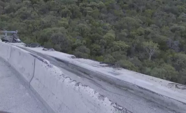 In this image taken from video provided by eNCA, a bus carrying worshippers headed to an Easter festival plunged off a bridge on a mountain pass and burst into flames in Limpopo, South Africa, on Thursday, March 28, 2024, killing multiple people, authorities said. (eNCA via AP)