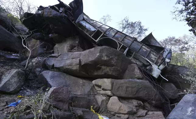 The wreckage off a bus lays in a ravine a day after it plunged off a bridge on the Mmamatlakala mountain pass between Mokopane and Marken, around 300km (190 miles) north of Johannesburg, South Africa, Friday, March 29, 2024. A bus carrying worshippers on a long-distance trip from Botswana to an Easter weekend church gathering in South Africa plunged off a bridge on a mountain pass Thursday and burst into flames as it hit the rocky ground below, killing at least 45 people, authorities said. The only survivor was an 8-year-old child who was receiving medical attention for serious injuries. (AP Photo/Themba Hadebe)