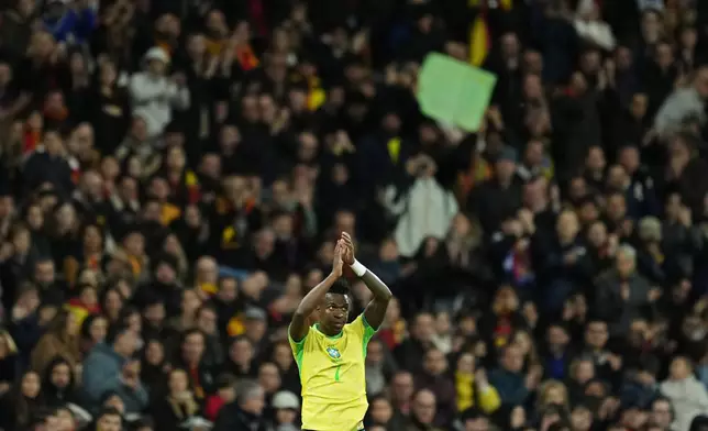 Brazil's Vinicius Jr applauds the fans after being substituted during a friendly soccer match between Spain and Brazil at the Santiago Bernabeu stadium in Madrid, Spain, Tuesday, March 26, 2024. (AP Photo/Jose Breton)