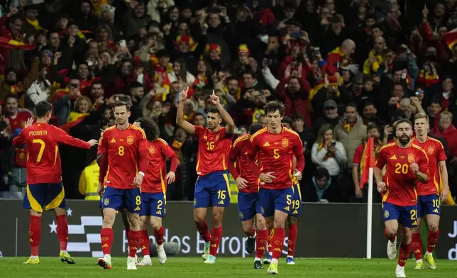 Spain's Rodrigo, centre, celebrates after scoring the opening goal with a penalty kick during a friendly soccer match between Spain and Brazil at the Santiago Bernabeu stadium in Madrid, Spain, Tuesday, March 26, 2024. (AP Photo/Jose Breton)