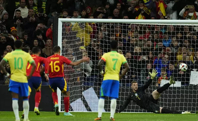 Spain's Rodrigo, 3rd left, scores the opening goal with a penalty kick during a friendly soccer match between Spain and Brazil at the Santiago Bernabeu stadium in Madrid, Spain, Tuesday, March 26, 2024. (AP Photo/Jose Breton)